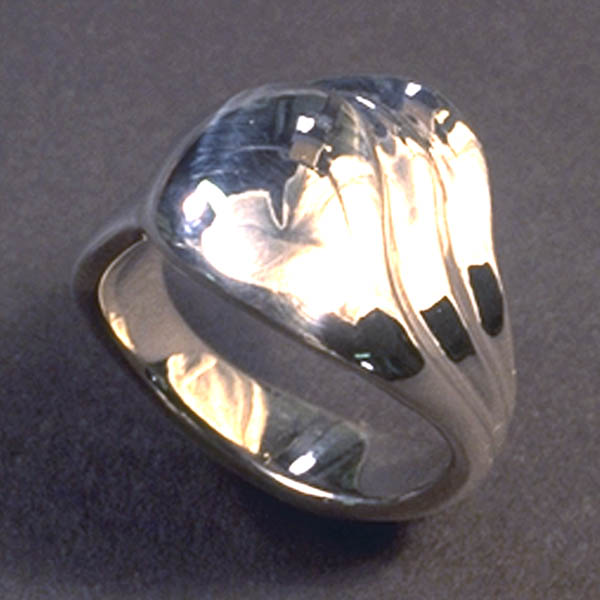 This silver ring has a rounded dome top with two additional layers curving around it.