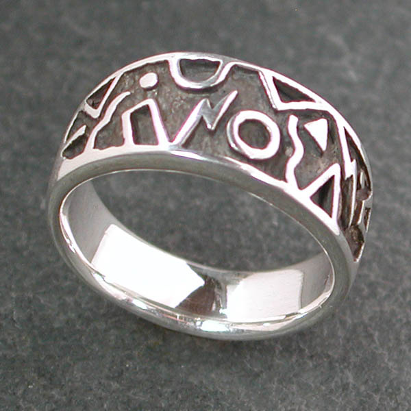 This medium wide silver band features geometric shapes with a textured dark background.