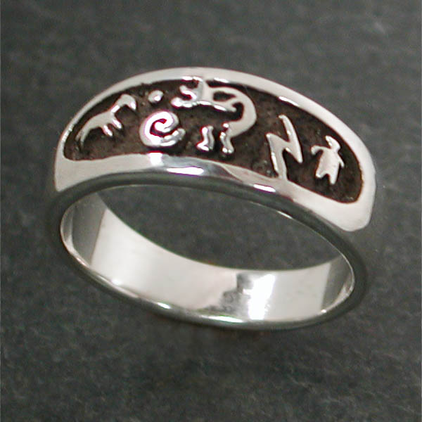 This comfortable sterling silver band shows petroglyphs against a recessed dark background.